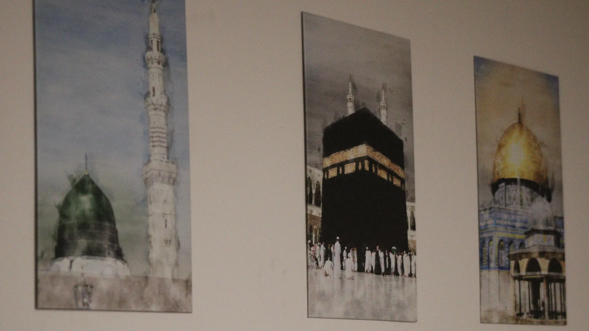 Duvarda İslam mimarisini gösteren üç çerçeveli suluboya: Yeşil Kubbe, Kâbe ve Kubbetü's-Sahra