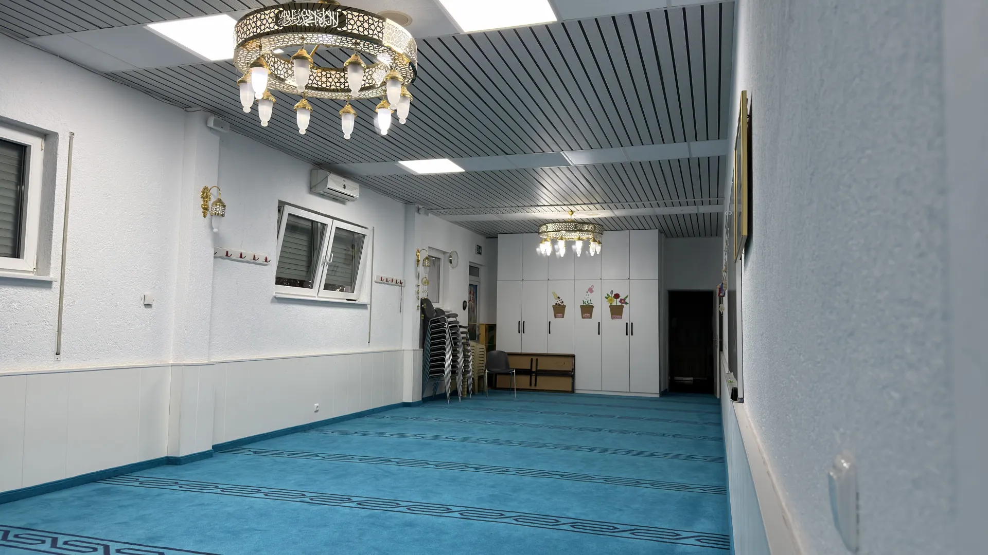 Mescidin yan odası: beyaz gömme dolaplar ve çocuk süslemeleri.